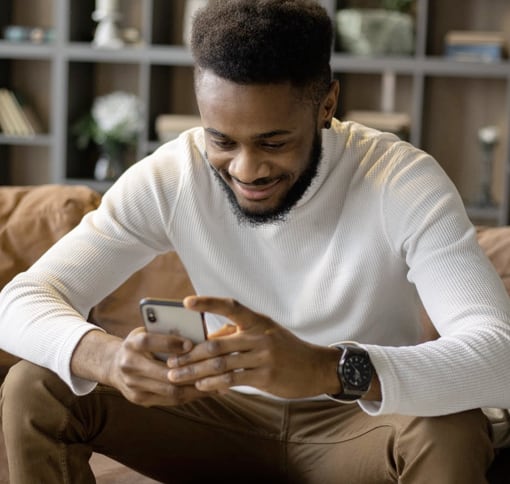 Image of a man texting on his smartphone while smiling